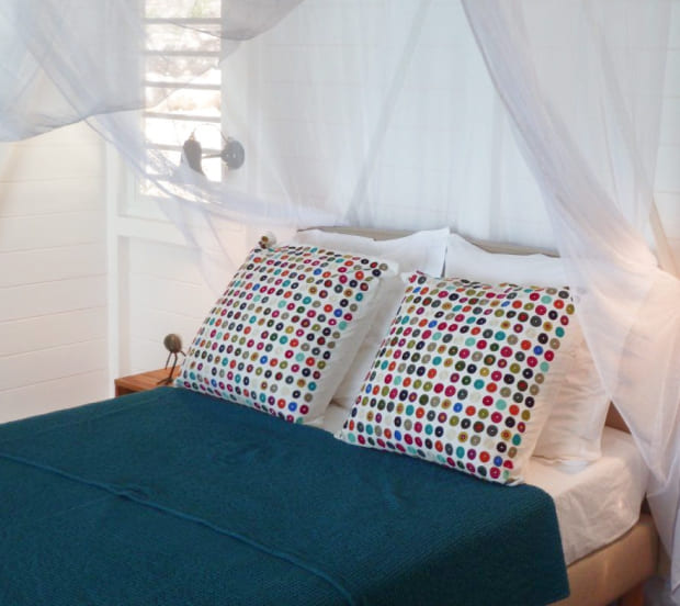 View of the double bed with mosquito net in one of the villa's bedrooms